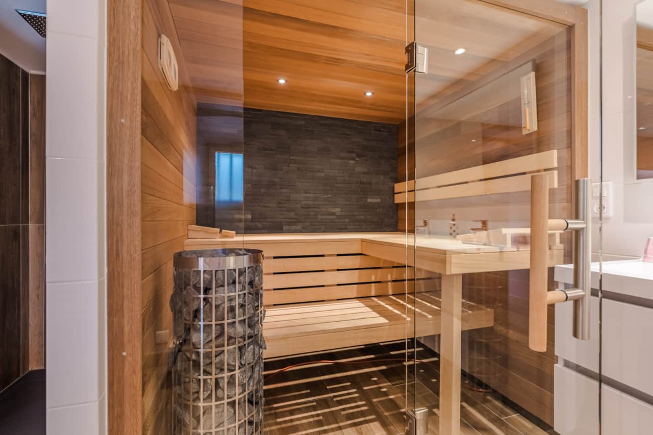 Relaxation area with private sauna, modern shower and double sink, for optimal comfort.