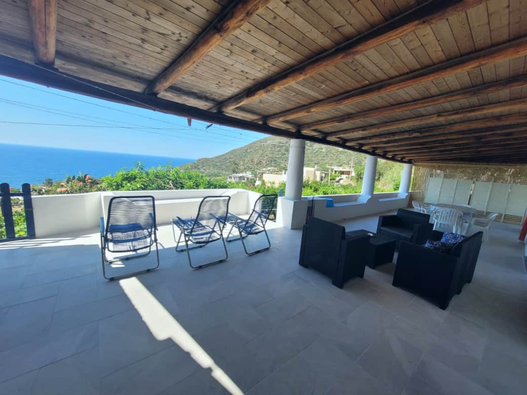 Veranda arredata con sedute, vista mare e collina a Pollara, isola di Salina