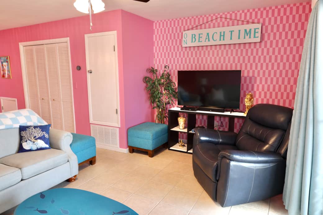 Living room area with TV, lounge chair, and queen sofa bed