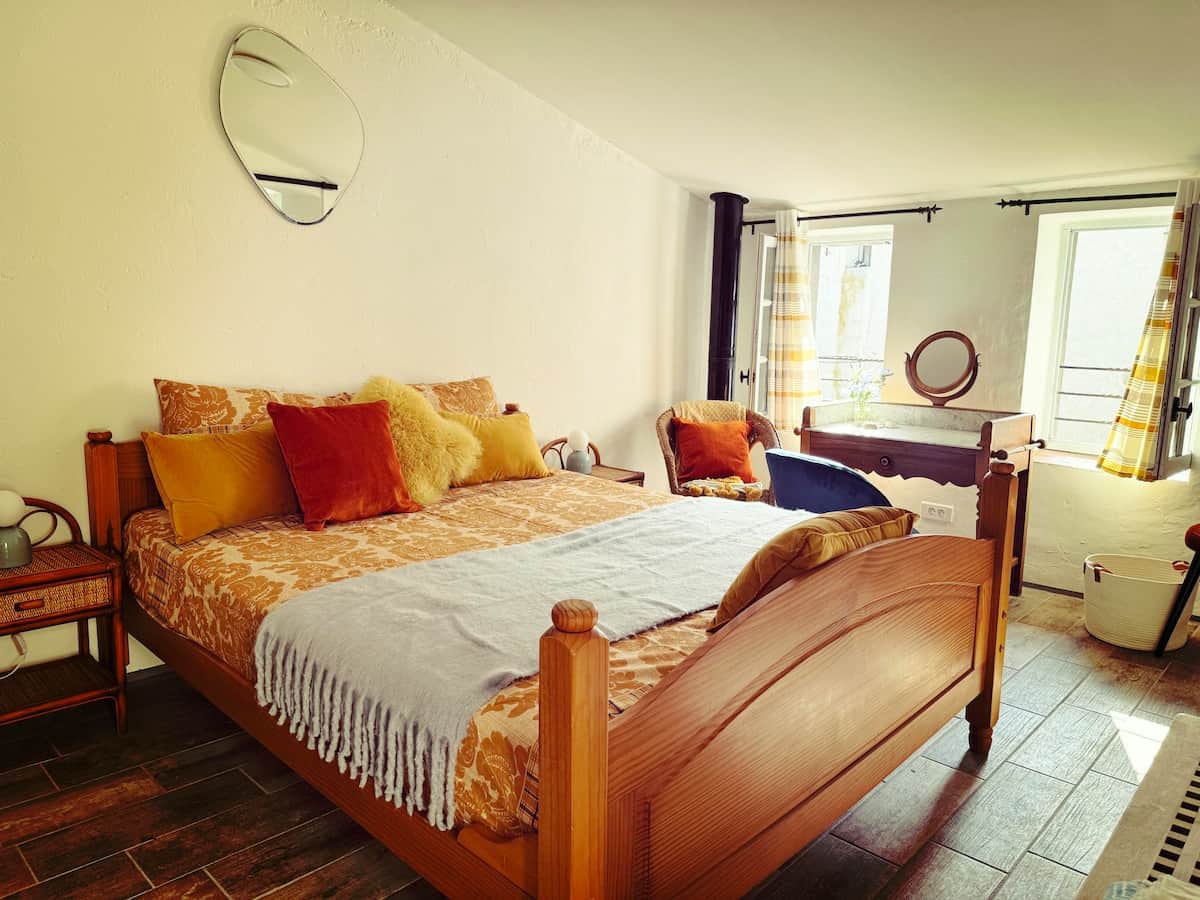 A bedroom on the first floor with a large bed and a charming vintage dressing table