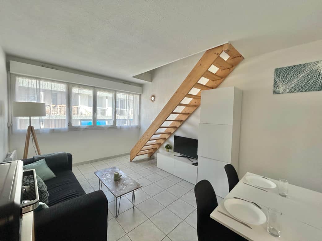 Living room, sofa, dining table, chairs, lamp, coffee table, TV, stairs
