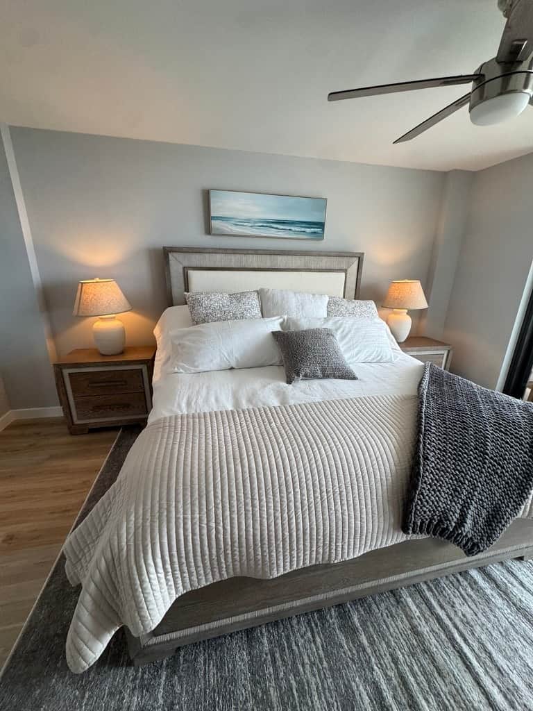 Peaceful primary bedroom with balcony access and beautiful water views.