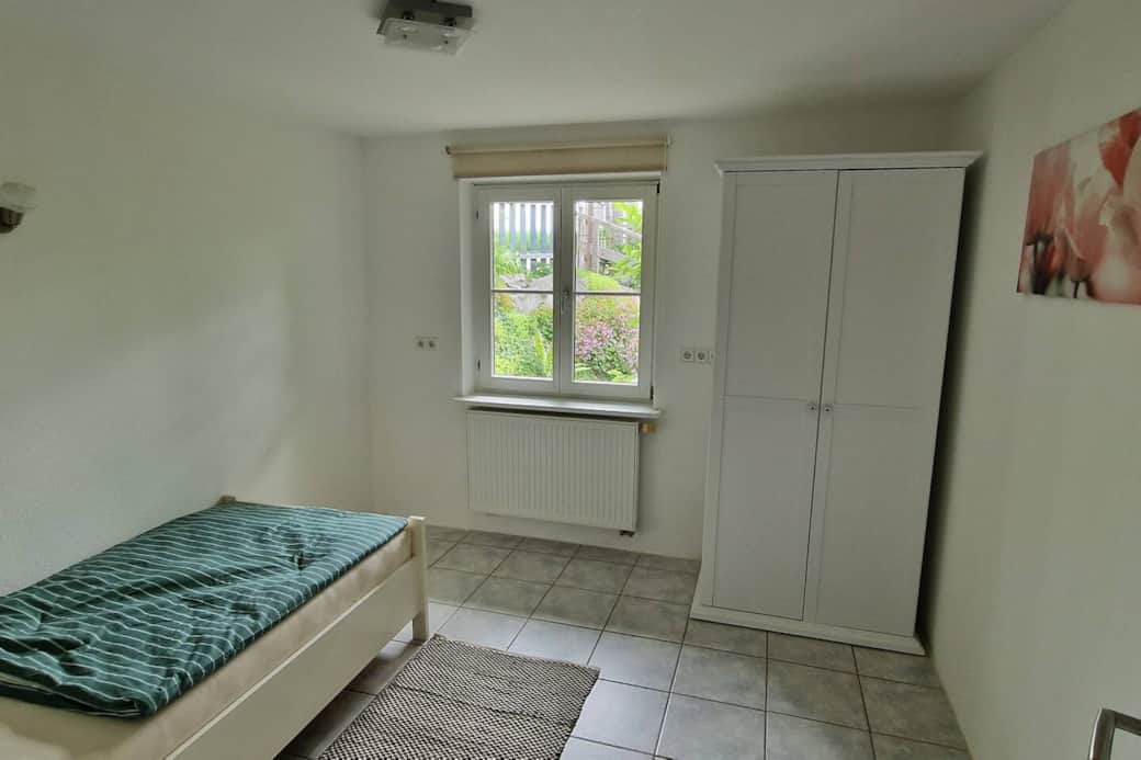 Schlafzimmer mit Einzelbett und Schrank in der Ferienwohnung bei Kißlegg Schlafzimmer mit Einzelbett und Schrank in der Ferienwohnung bei Kißlegg