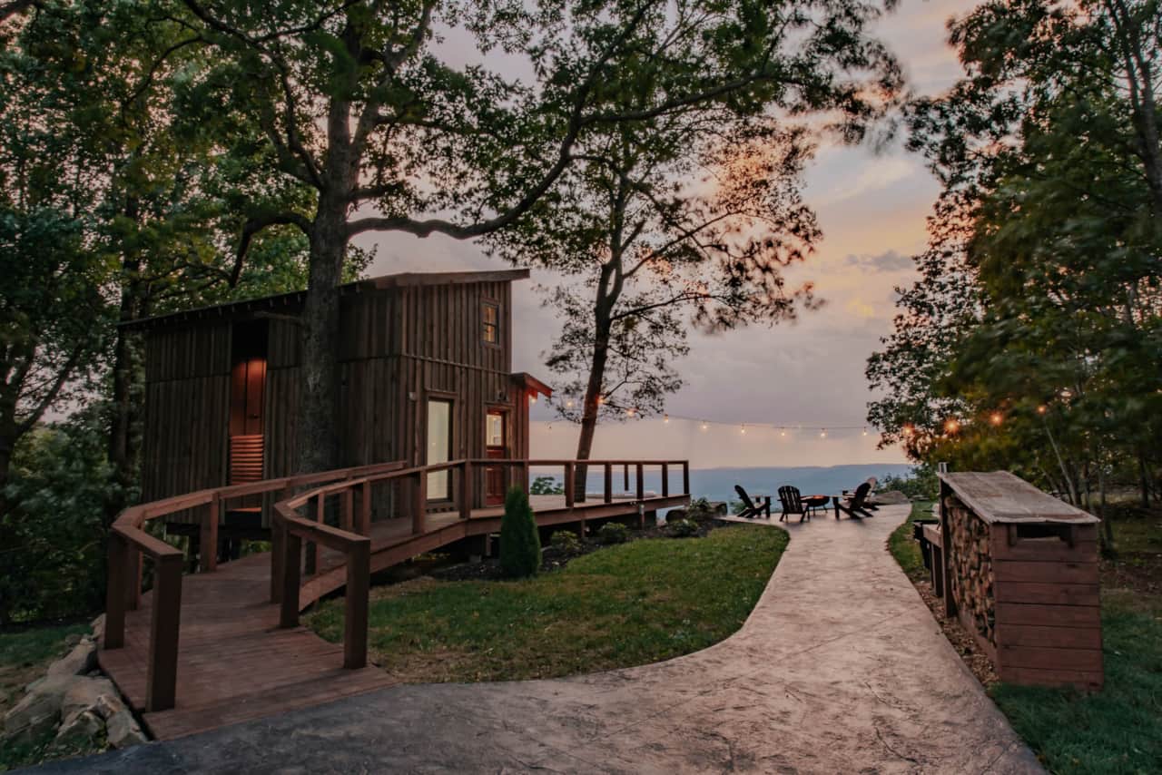 The Artistree House glows beneath a breathtaking mountain sunset.
