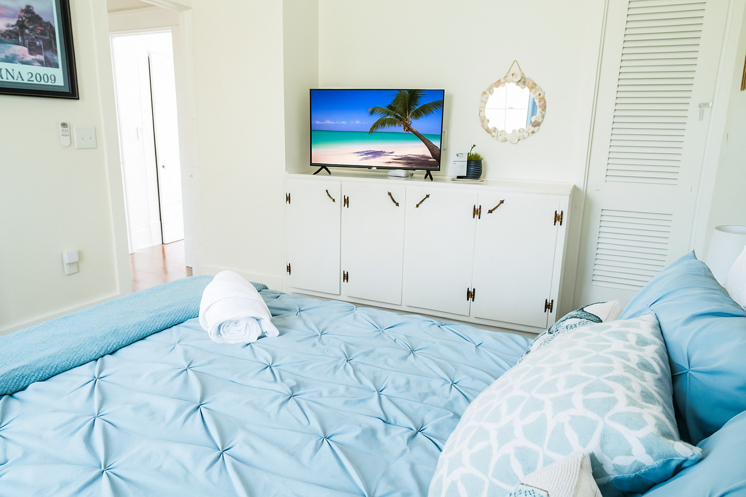 Coastal-themed bedroom with TV.