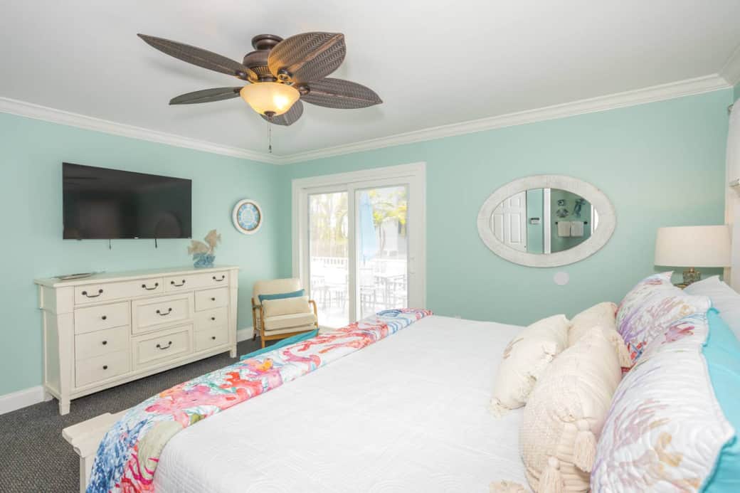 Rest deep in a king room with memory-foam luxury, bright linens, and coastal lamps.