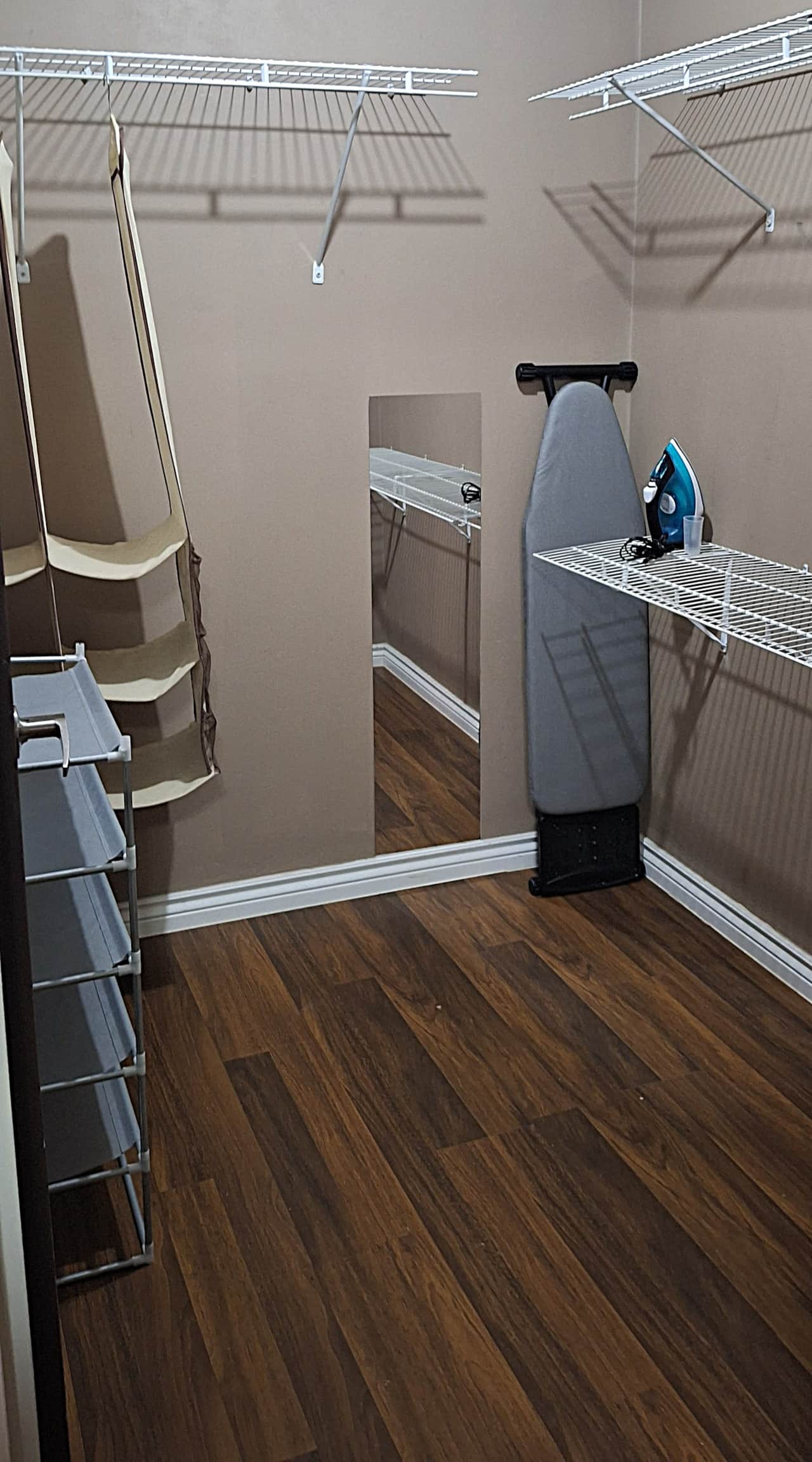 Closet with shelving, storage, iron and ironing board