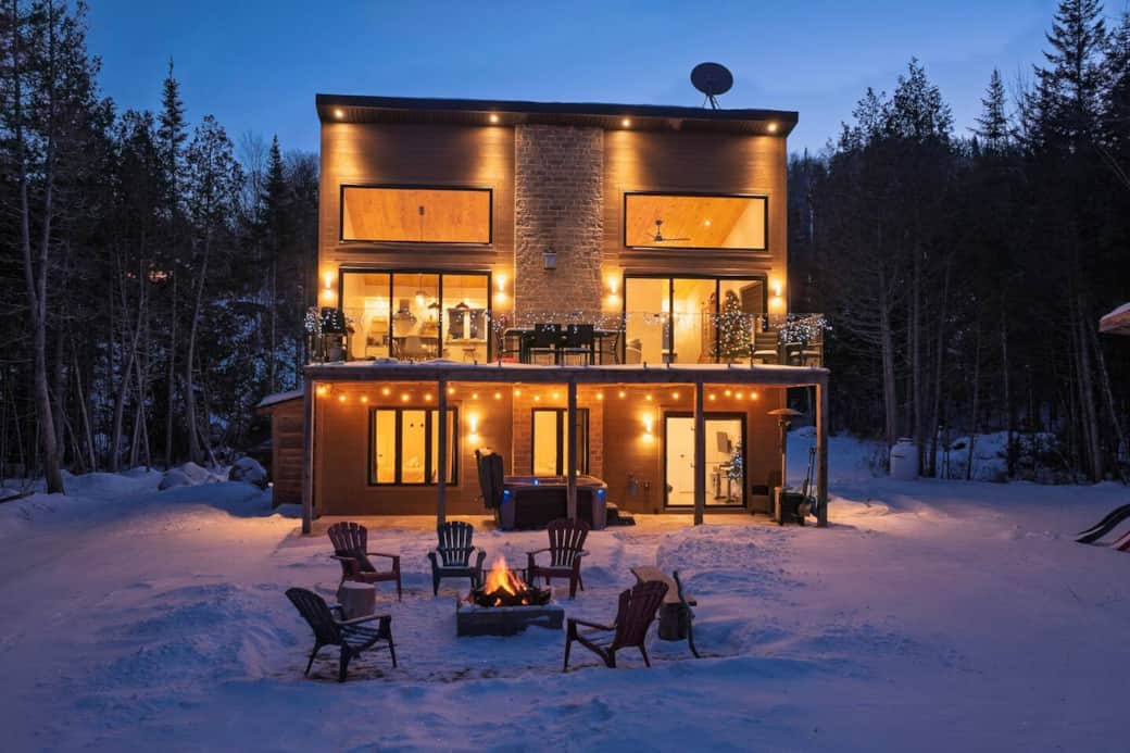 Extérieur bien illuminé, coin feu avec chaises, spa, terrasse/Well-lit exterior, fire pit with chairs, spa, terrace.