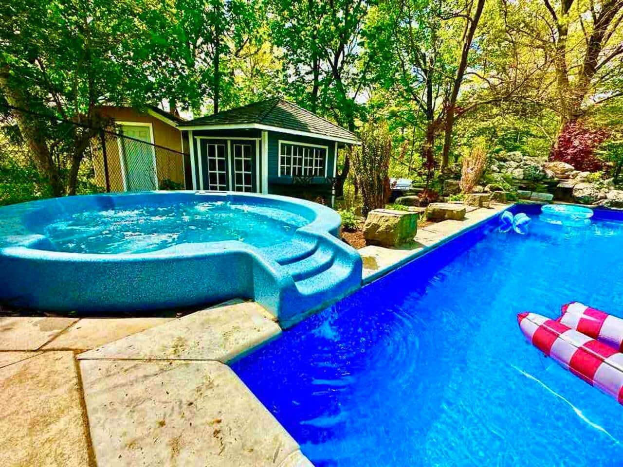 Our backyard offers a true resort like feel with a pool and connected tub, water fall, lounge chairs and a view of the beautiful ravine. 