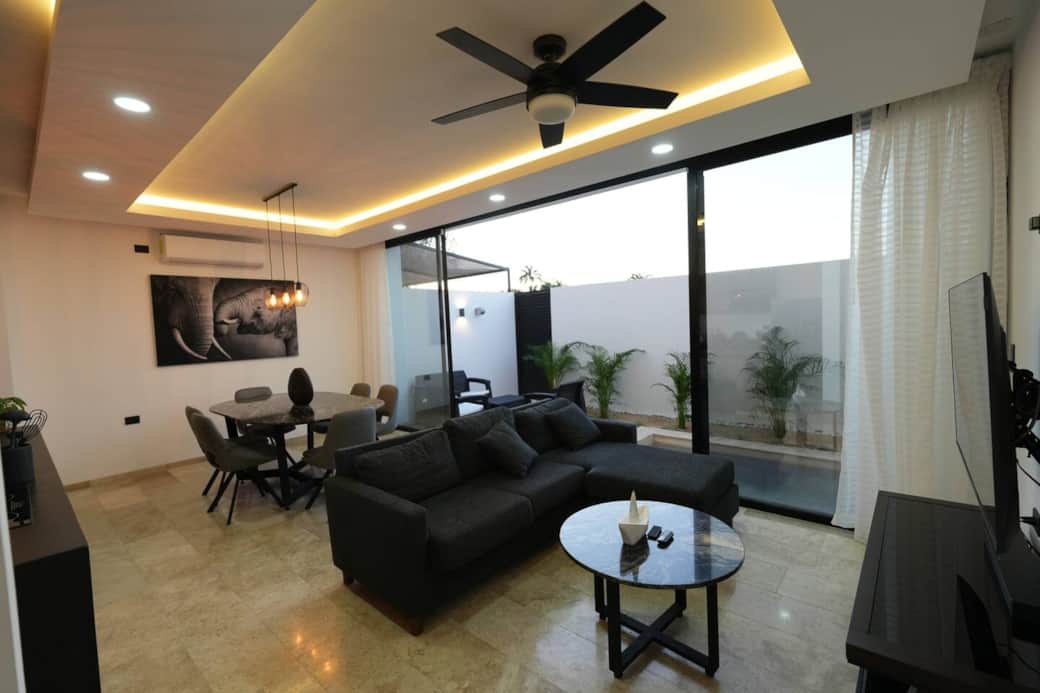 Sala con distintos ambientes e ilumunación ad-hoc a la ocasión, con Smart TV, barra de sonido premium, aire acondicionado y ventilador.