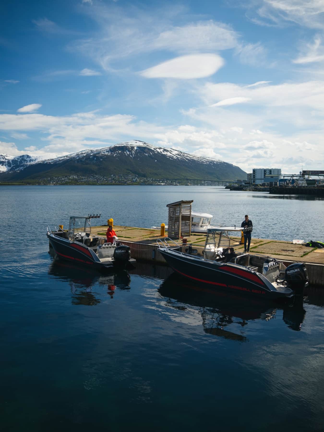 Boat crossing open water toward the Lyngen Alps