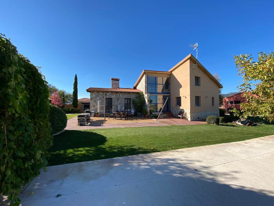 Vista de la casa por su fachada este, la que da al jardín y a la piscina.