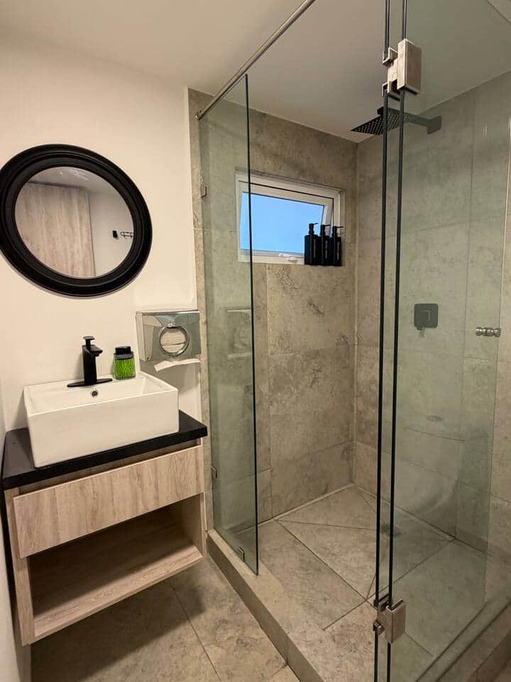 Modern, spa-style bathroom with a glass walk-in shower, rainfall showerhead, sleek vanity sink, and fresh neutral finishes—clean, bright, and perfect for a relaxing reset. Modern, spa-style bathroom with a glass walk-in shower, rainfall showerhead, sleek vanity sink, and fresh neutral finishes—clean, bright, and perfect for a relaxing reset.