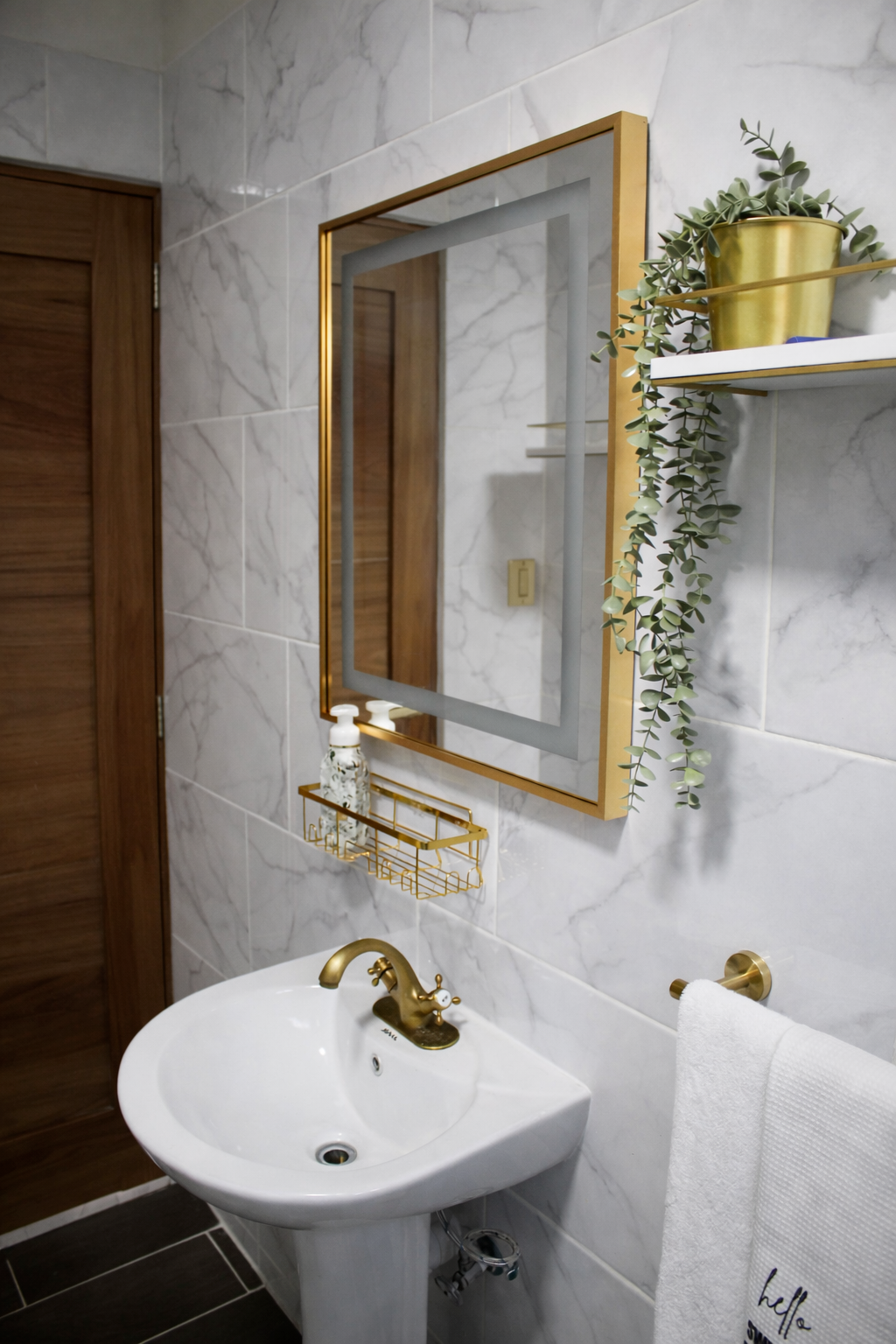 Elegant bathroom with marble-look tile, gold fixtures, and a modern spa-inspired feel.