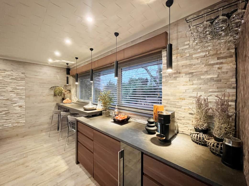 Chic Bar Area - Under subtle lighting, and overlooking the serene back garden. Complete with a wine cooler, fridge, and stylish seating, this bar area is perfect for unwinding or entertaining in style