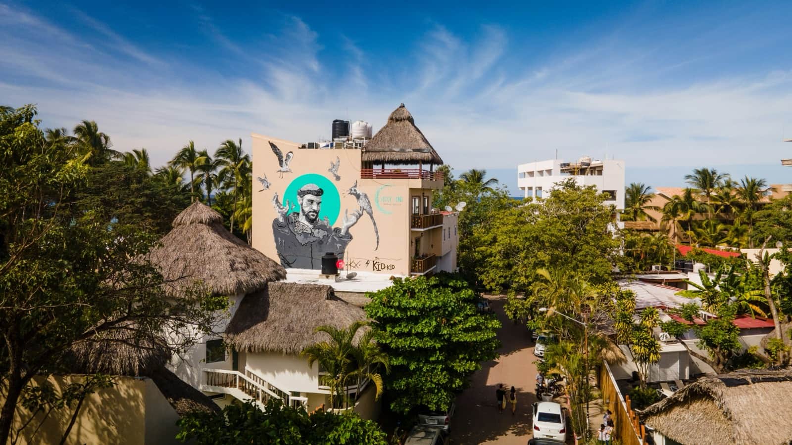 Palapa rooftops, palms, and a large mural on a building in San Pancho (San Francisco), Nayarit