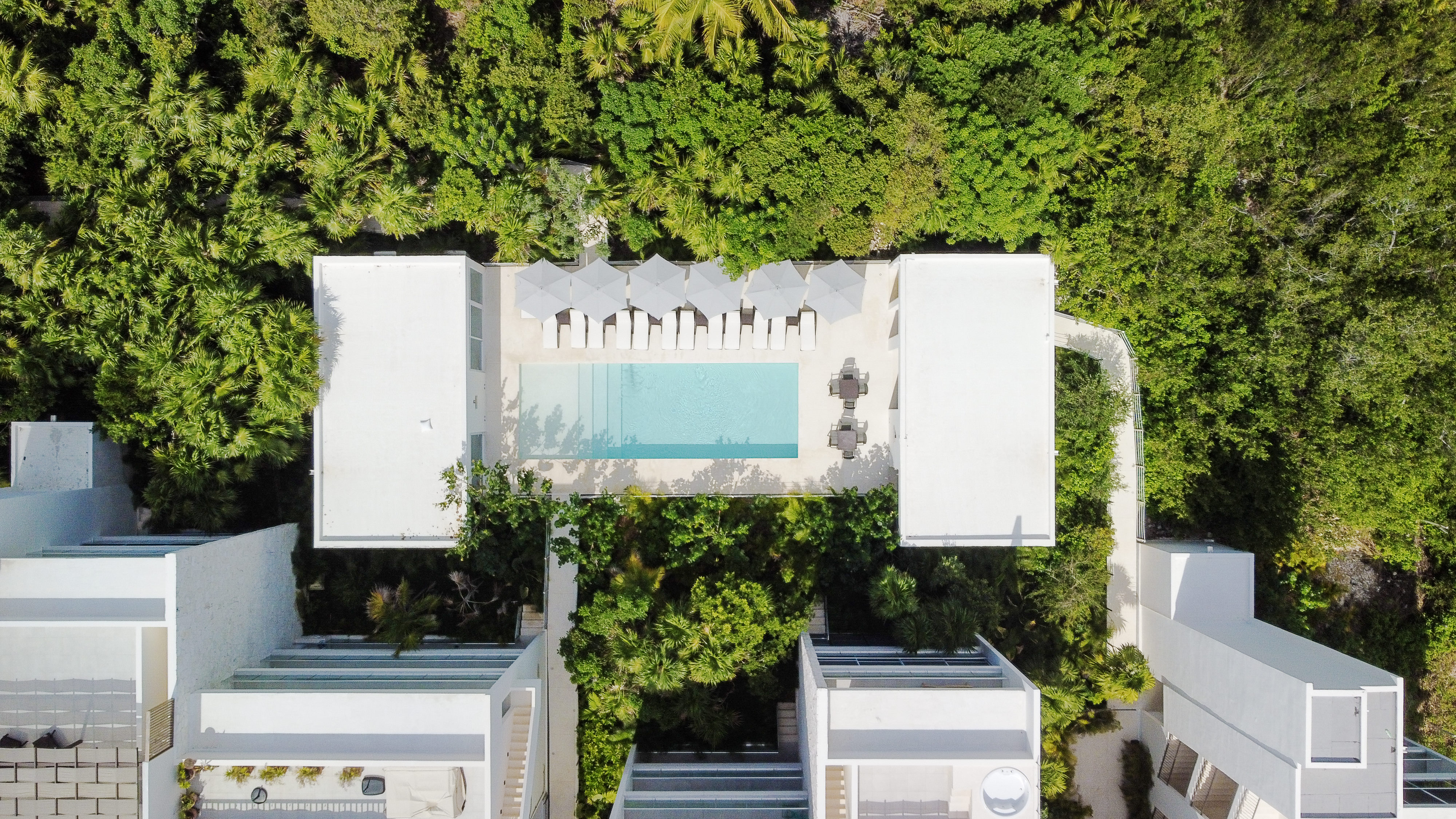 Drone view of the lush jungle and resort pool, just steps from your condo for easy relaxation.