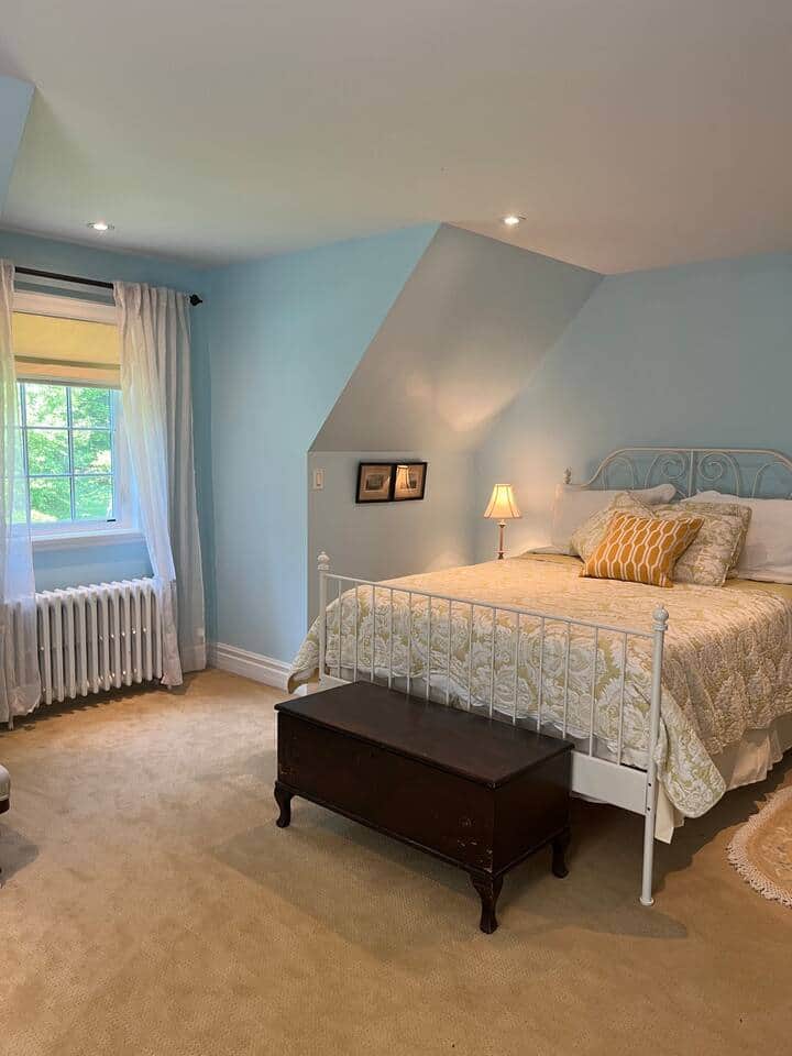The Massey Bedroom Suite as it overlooks a lovely pool & majestic spruce trees. Air conditioned.  Keyed lockable privacy door. Full bathroom. Armoire. Behind the trees are the faint remnants of the initial Massey log house. 