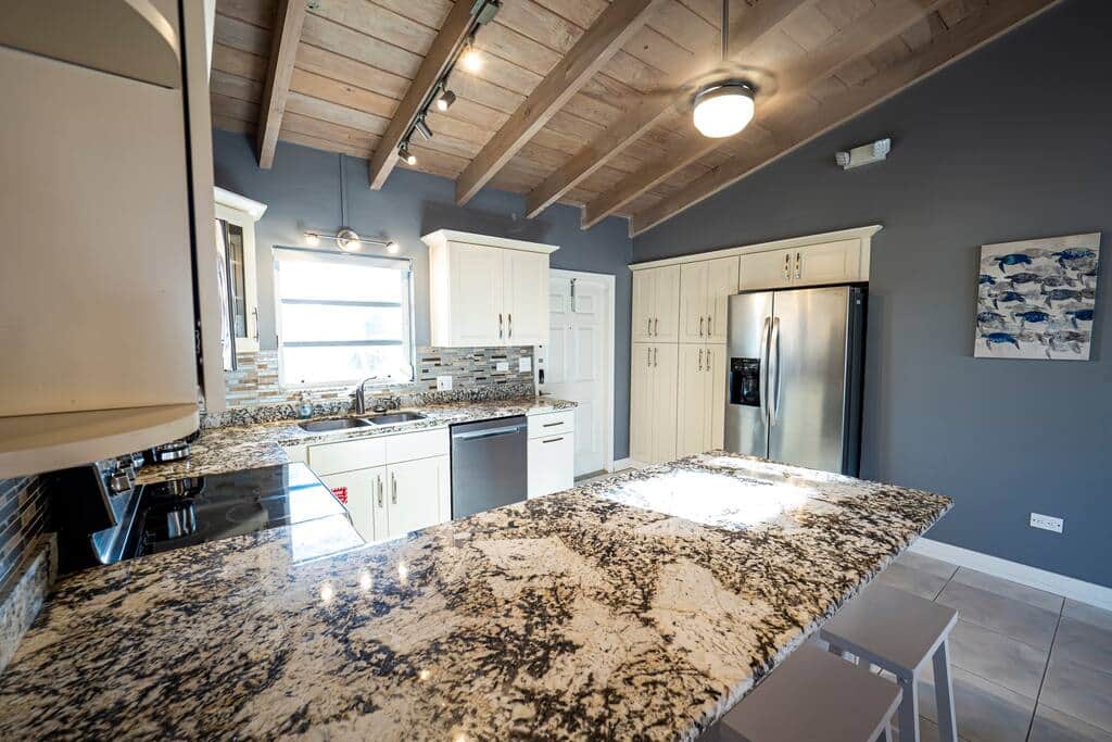 Kitchen - Granite counters with room to spread out, a full size stainless refrigerator and prep spac
