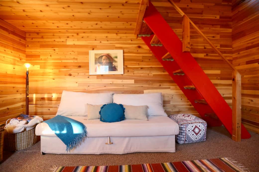 This comfortable sofa turns into a cozy double bed, stairs lead up to the sleeping loft. This comfortable sofa turns into a cozy double bed, stairs lead up to the sleeping loft.