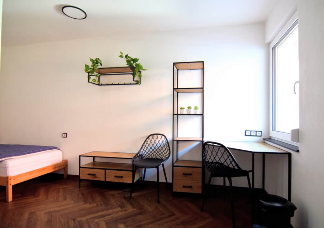 Schlafzimmer mit Tisch und Sessel