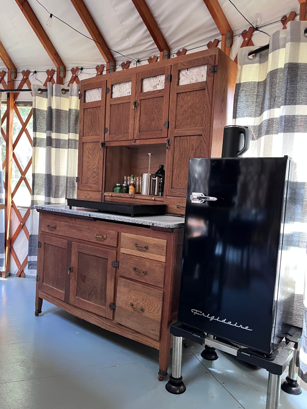 Simple kitchenette with induction stove and coffee setup inside the yurt.