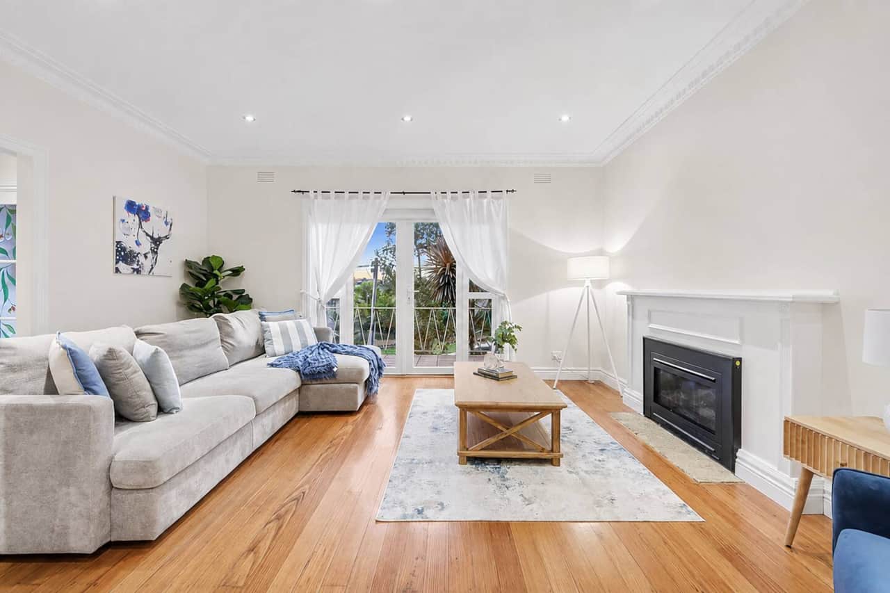 Bright main lounge with fireplace, timber floors and garden outlook. A comfortable separate living space for families settling in for longer stays.
