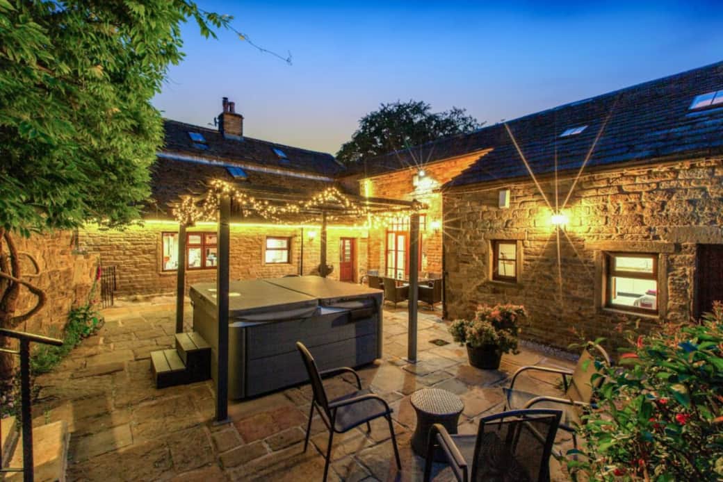 The heated 7 person hot tub is in a private courtyard with a canopy & fairy lights 