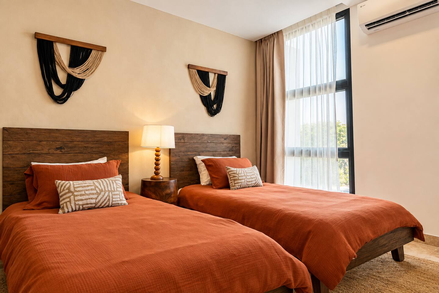 Esta recámara no solo ofrece 2 camas individuales, aire acondicionado, ventilador de techo, ropero, Smart TV y espacio de trabajo dedicado; también cuenta con lámpara de buró, contactos junto a las camas para cargar dispositivos fácilmente y relajantes vistas a la vegetación.
