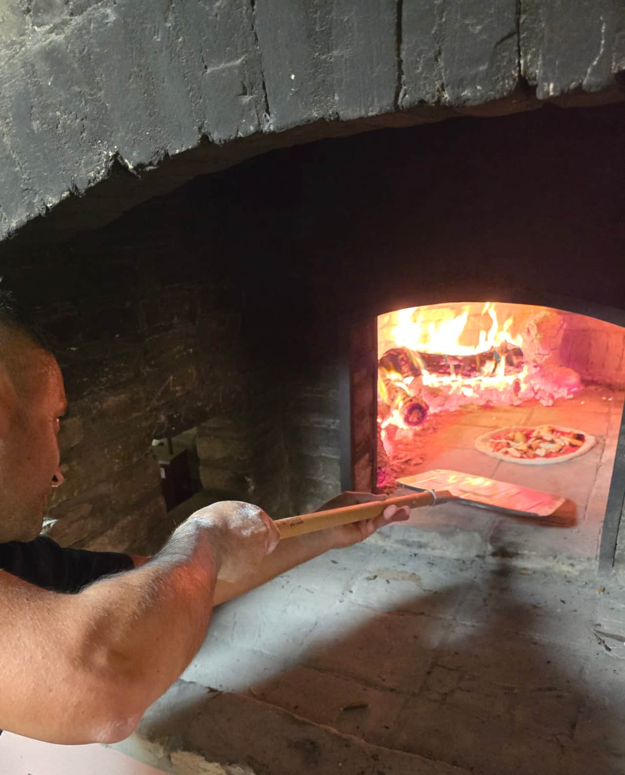 Traditional stone oven with a freshly baked pizza