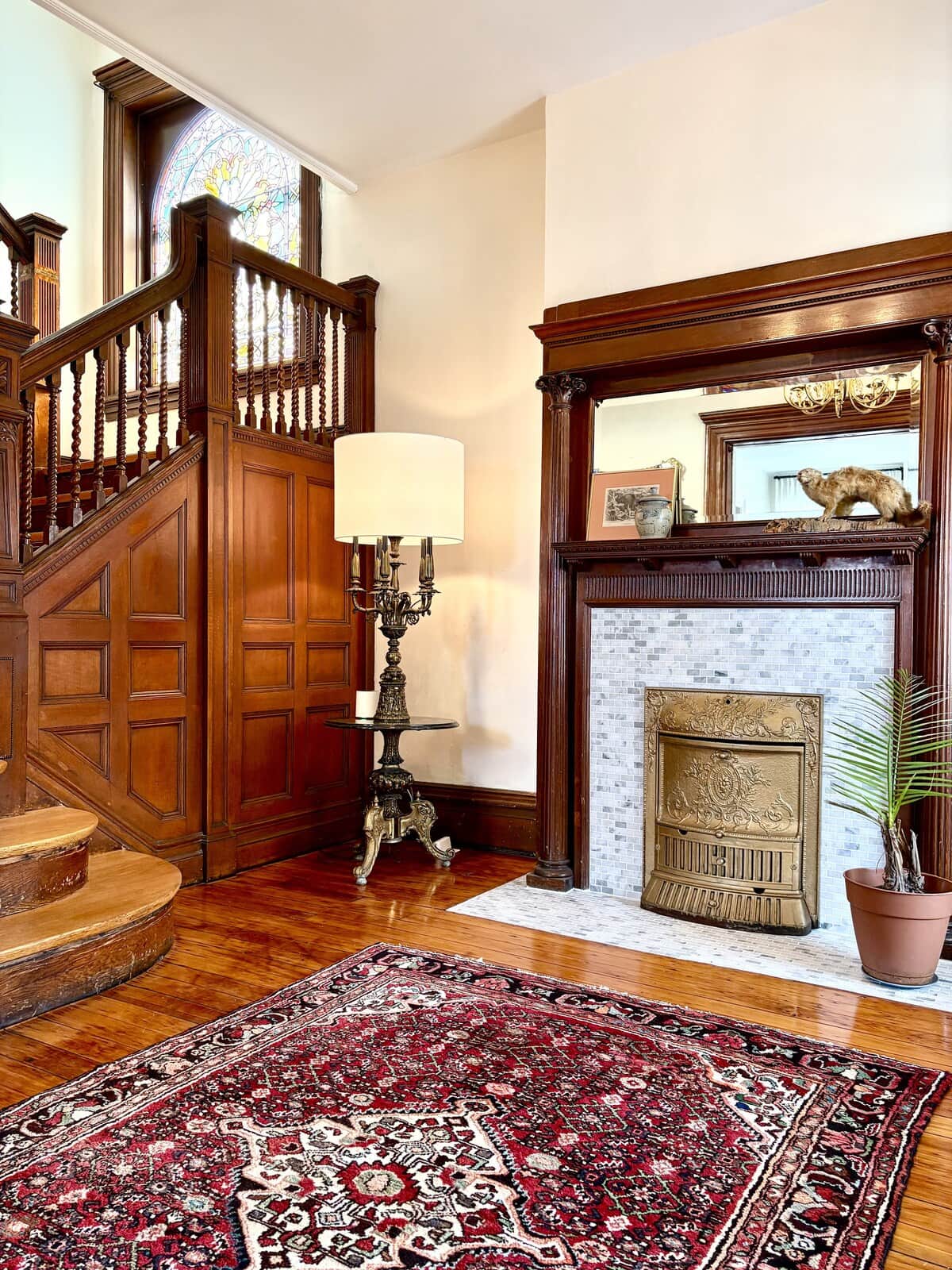 The original 1910 staircase — turned spindles, raised-panel wainscoting, all of it still here