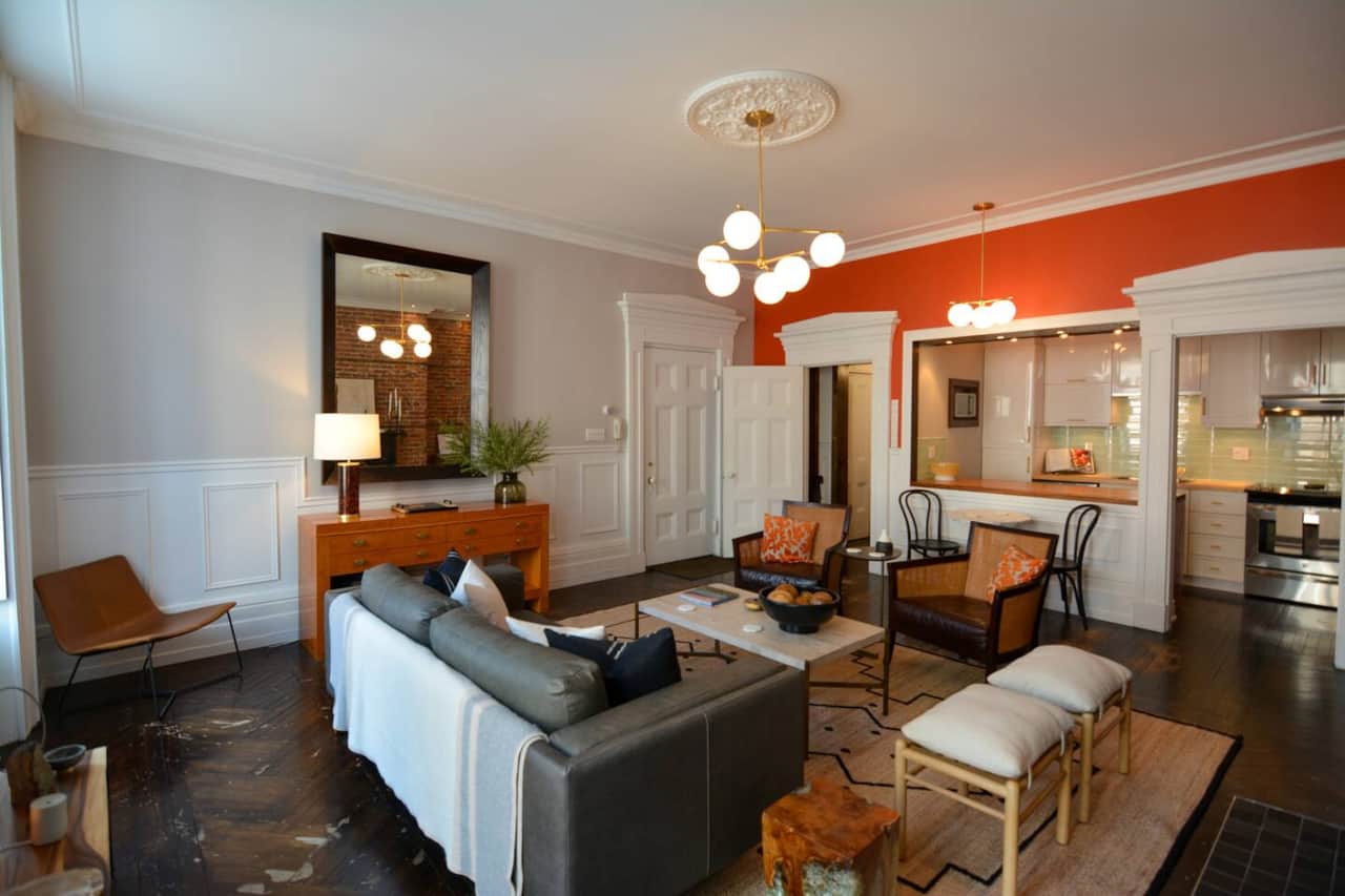 Relax in a stylish living space with exposed brick, original hardwood floors, and cozy décor.