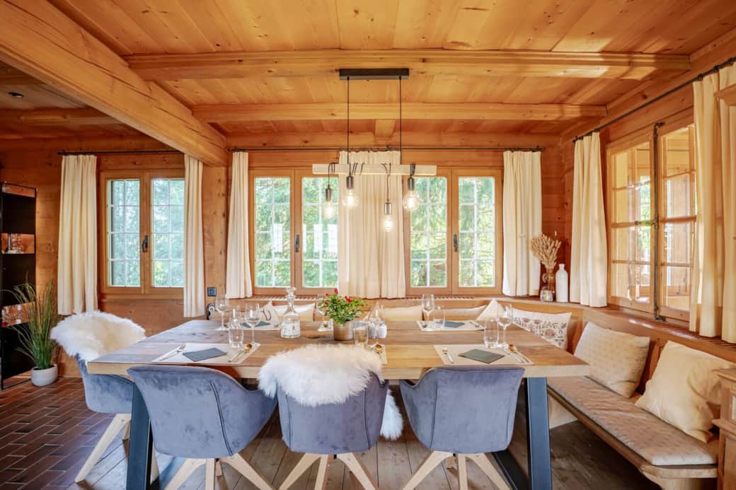 Experience the charm of our rustic dining and living space, featuring a magnificent oak table and a cozy corner bench that seats up to 10 people, all beside a warm, inviting fireplace.