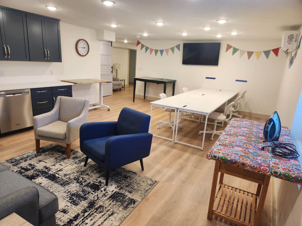 Sewing studio for six has two cutting tables, two ironing stations, and comfortable sewing chairs.