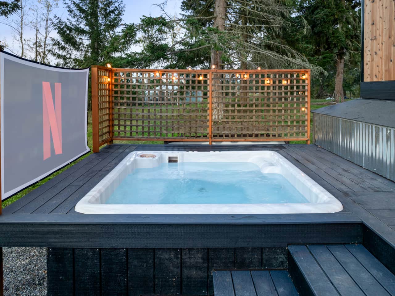 Built in hot tub with an outdoor movie screen and projector.