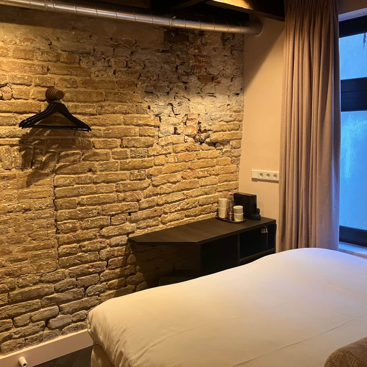 View across the Robinah Suite from the bed, toward the desk and window