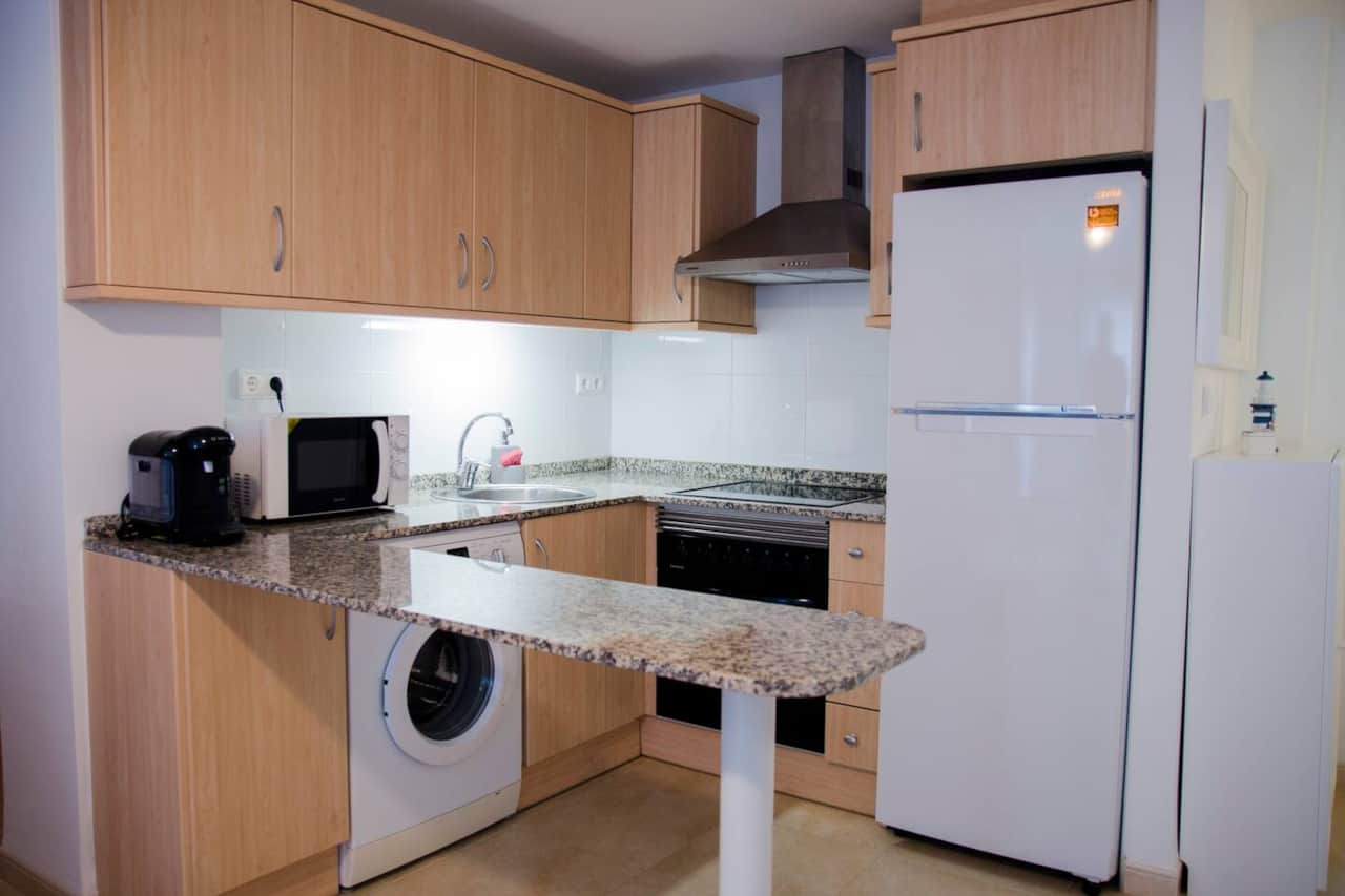 Cocina con horno, microondas, lavadora y nevera