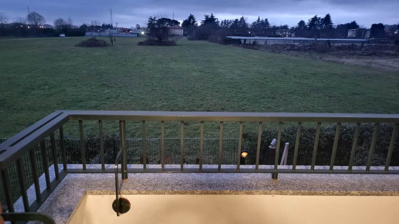 Balkon mit Geländer und Blick auf die grüne Wiese