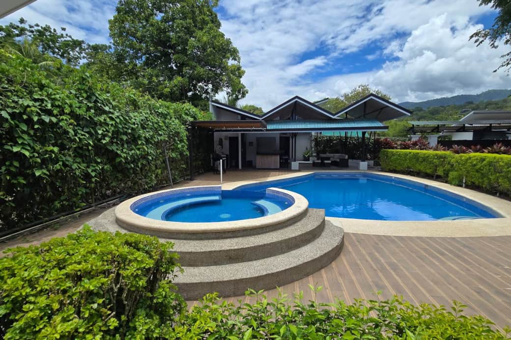 Your private oasis — complete with a jacuzzi, pool deck, and outdoor bar surrounded by tropical greenery