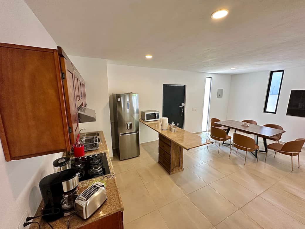 Open living space: living room, kitchen, dining area, patio