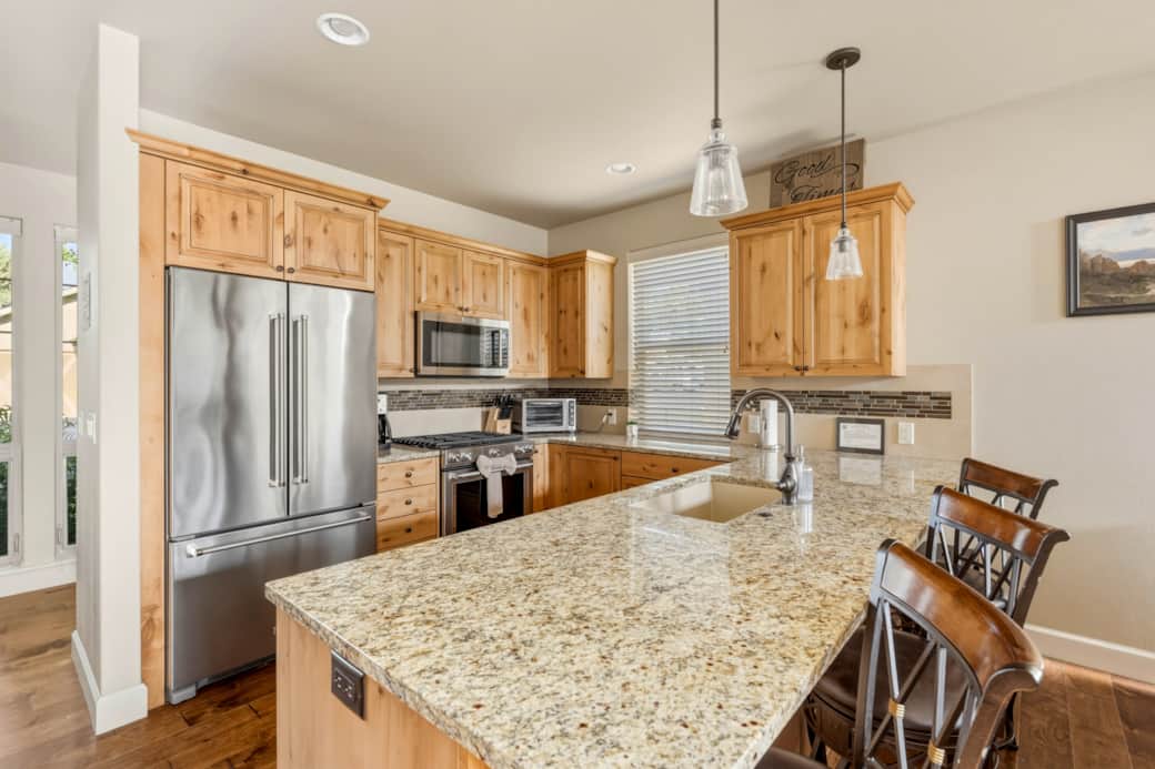 Gourmet kitchen — granite island, KitchenAid appliances, gas range, knotty alder cabinets.