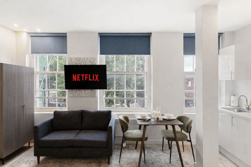 A bright, stylish dining and lounge space framed by large windows, A bright, stylish dining and lounge space framed by large windows,