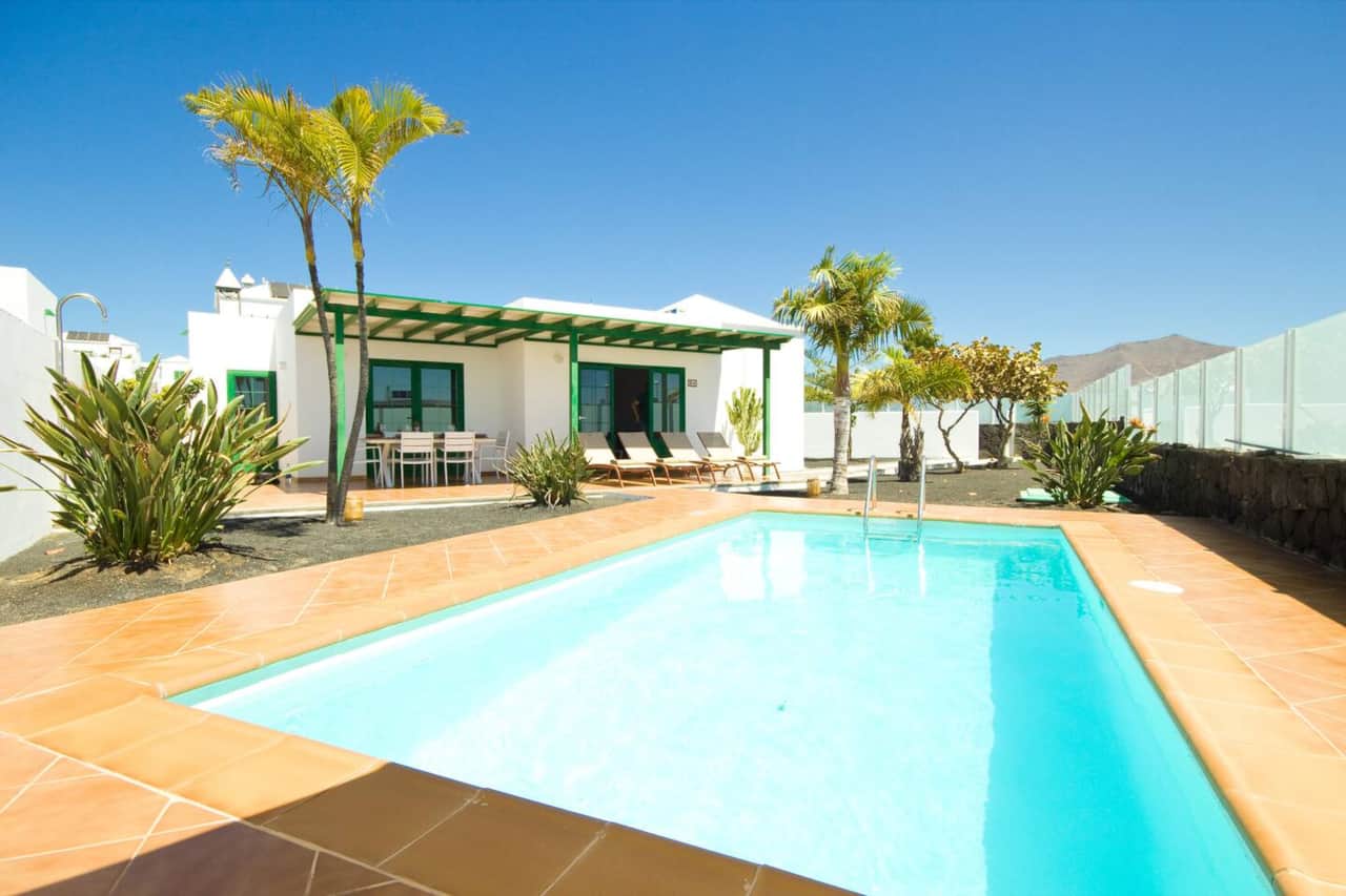 Private swimming pool surrounded by sun loungers at a holiday villa in Playa Blanca Lanzarote