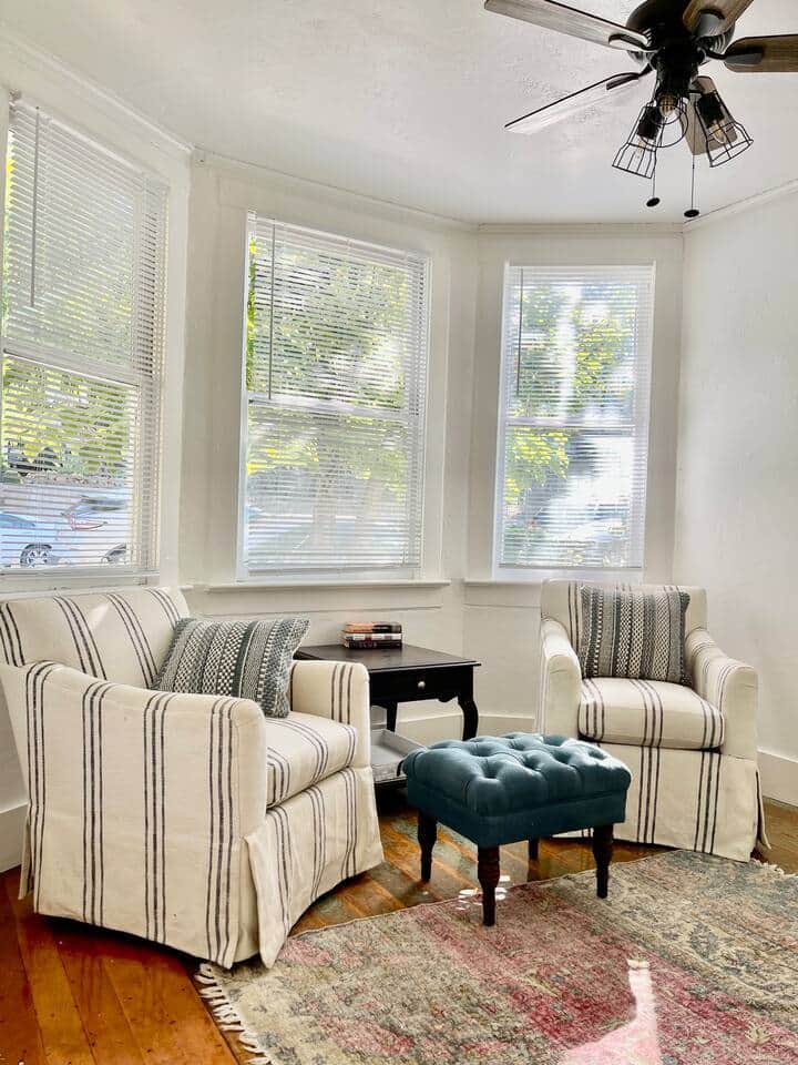Step into this bright and inviting reading room, where natural light pours through large windows, offering a serene view of the lush front yard. Perfect for curling up with a book, this cozy space is designed for relaxation and tranquility.