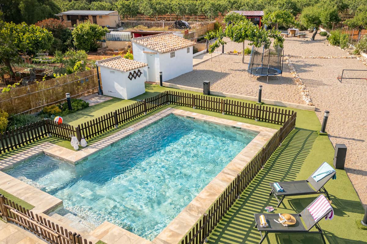 Piscina vallada con vistas a la fachada y al jardín |Masía de Cholito 