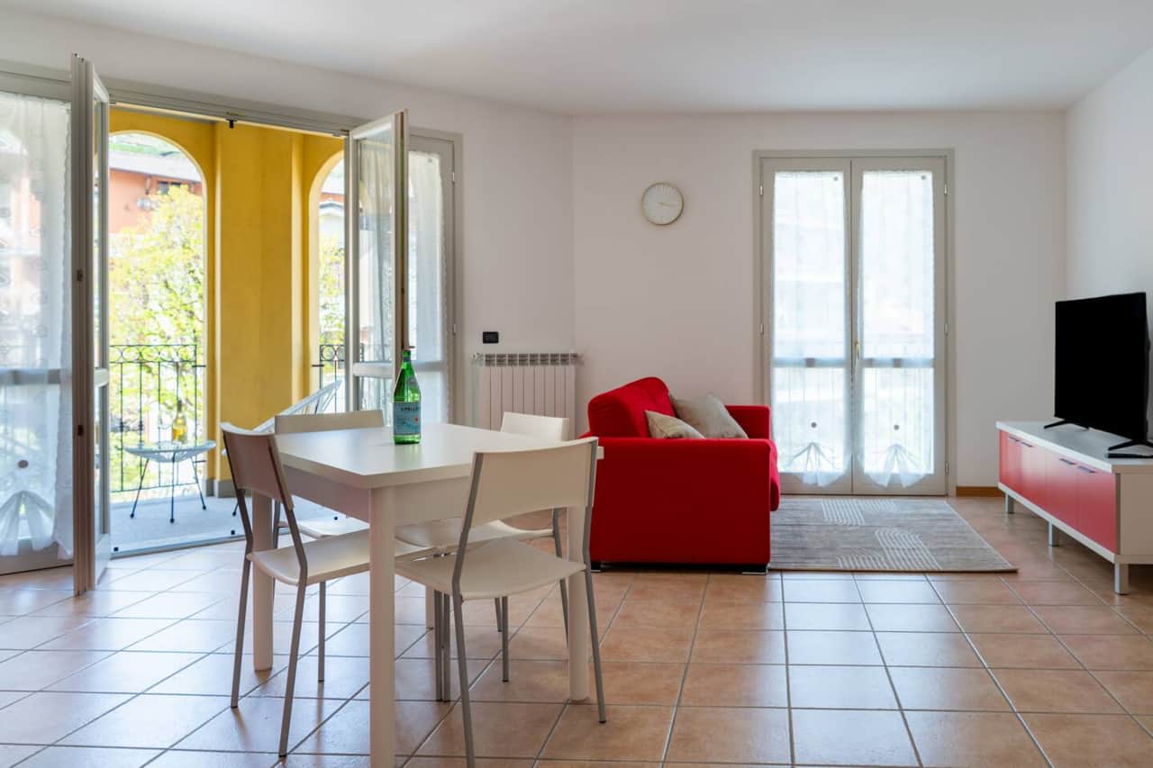 Ampio ed accogliente soggiorno con divano letto, smart TV, cucina open space e accesso diretto al balcone