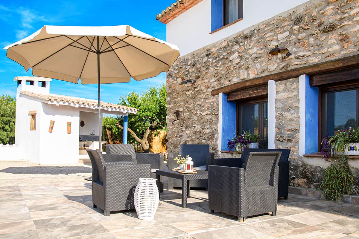 Porche rústico con zona de relax y mobiliario de exterior | Masía de Cholito