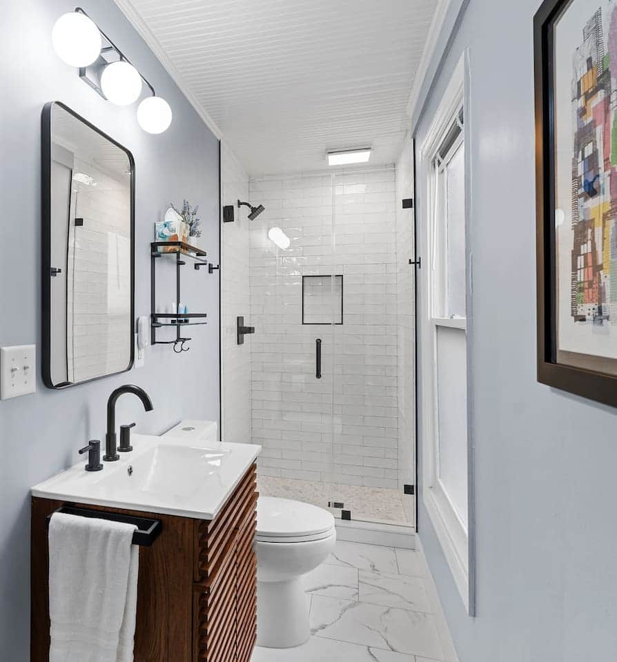 Bathroom #2 Renovated in Oct 2024 featuring tiled shower,  a dual flush toilet, and new vanity. Hair dryer and toilet paper under the sink.  A full length mirror is directly behind this camera shot. Please note that this bathroom has a step to enter.
