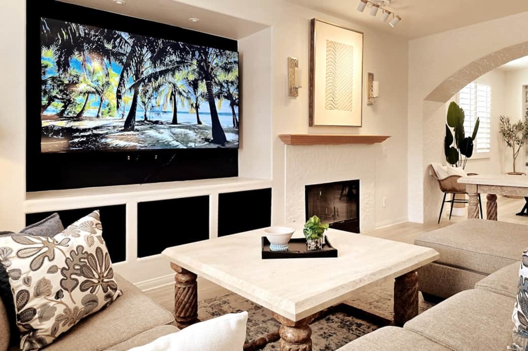 Living room with large, comfortable sectional sofa with chaise lounge, coffee table and 87" 4K Smart TV.