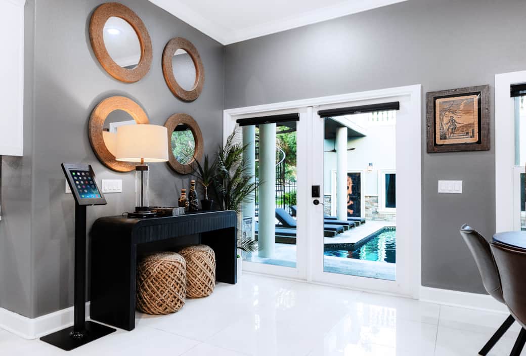 Sleek console setup behind the kitchen table, featuring rope-framed mirrors and tropical accents. Sleek console setup behind the kitchen table, featuring rope-framed mirrors and tropical accents.
